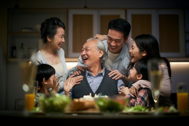Une famille vietnamienne sur plusieurs générations réunie autour d'un grand-père souriant