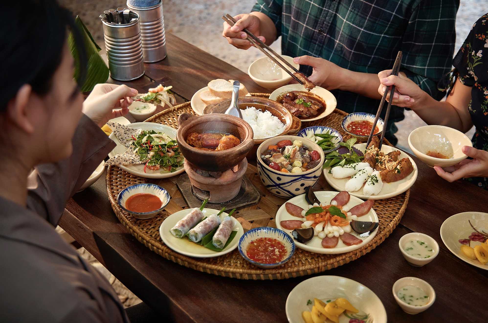 Repas familial rassemblant plusieurs générations autour d'une table vietnamienne