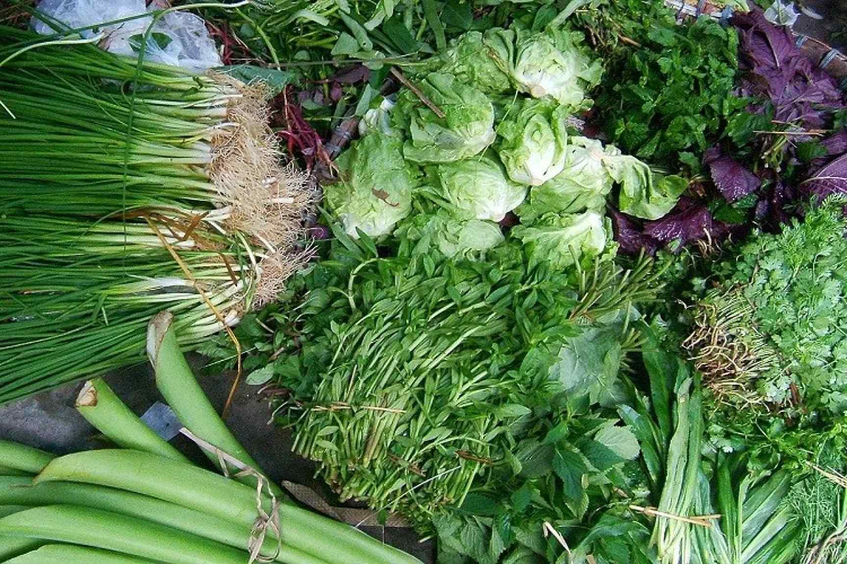 Étal de marché vietnamien garni d'herbes aromatiques et de légumes frais
