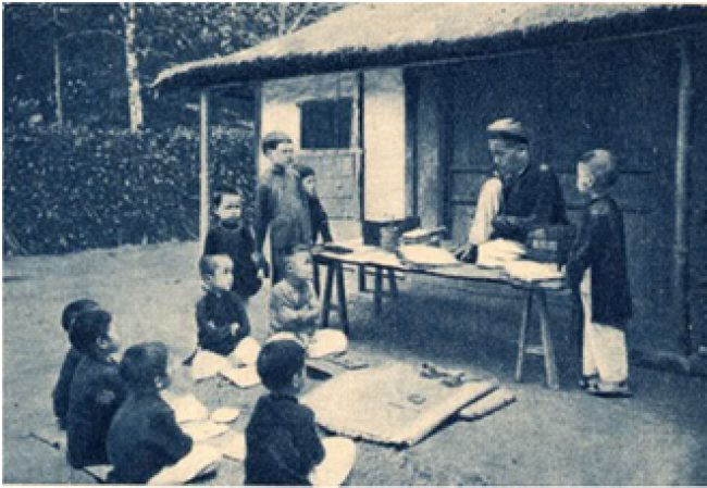 Alte Illustration eines thầy đồ, der seinen Schülern chinesische Schriftzeichen beibringt