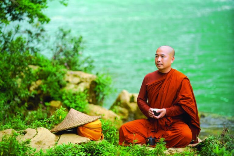 Moine bouddhiste Theravada en méditation au bord d'une rivière
