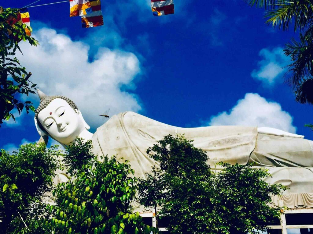 Drapeaux bouddhistes flottant devant le visage du Bouddha couché