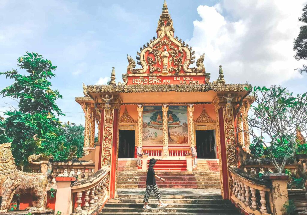 Pavillon rouge et or portant une inscription en khmer, à l'entrée de la pagode