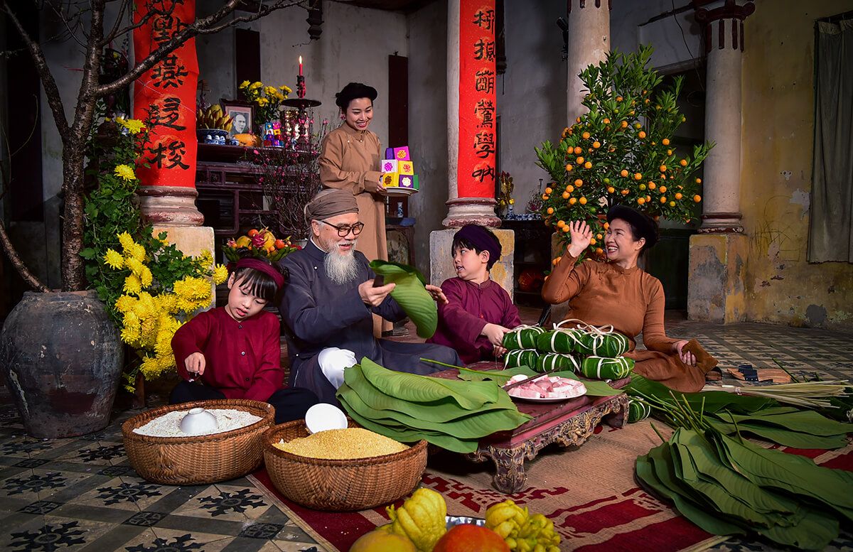 Une famille vietnamienne confectionnant des gâteaux banh chung pour le Têt