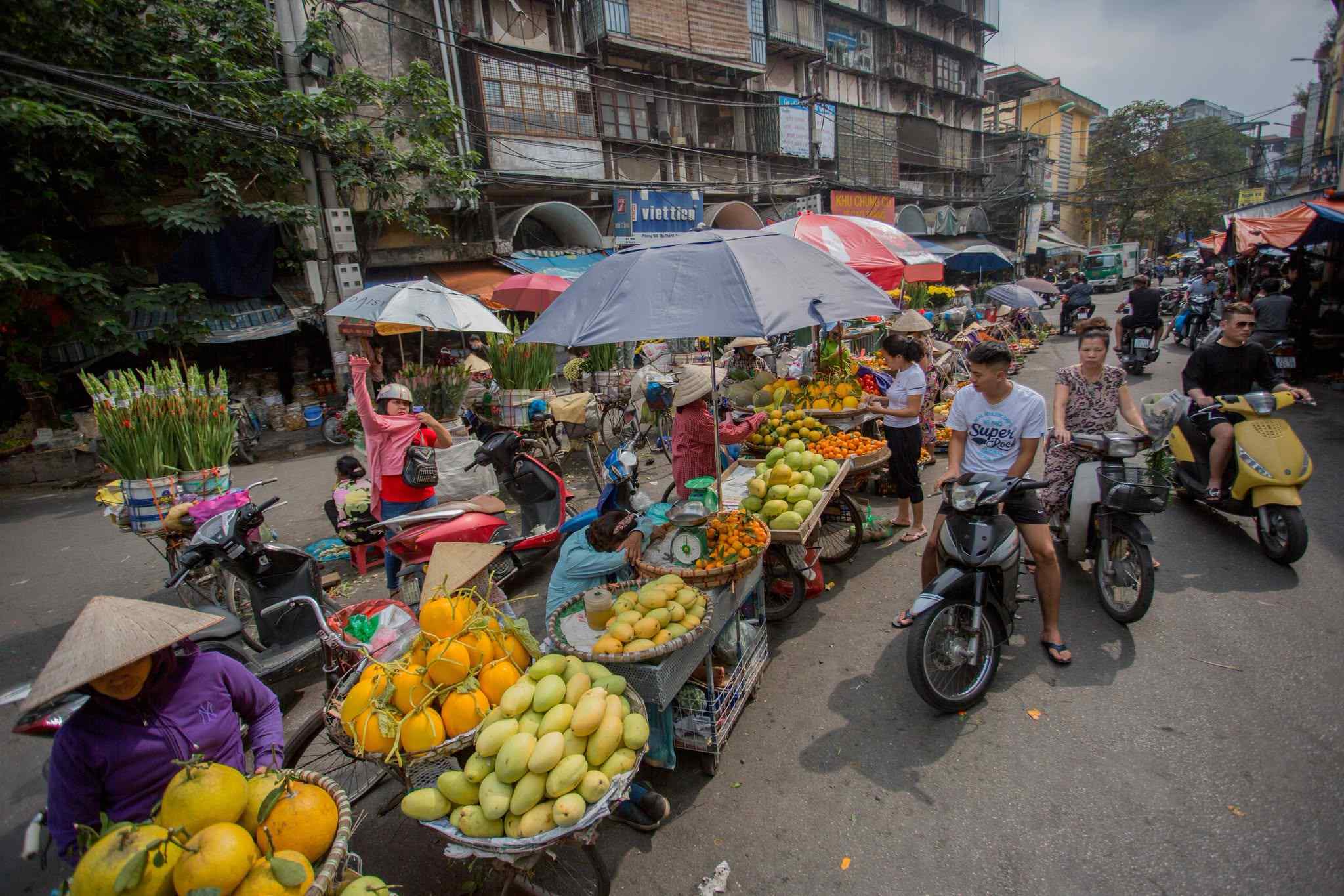 Une rue animée de Hanoï avec des vendeurs ambulants et des scooters