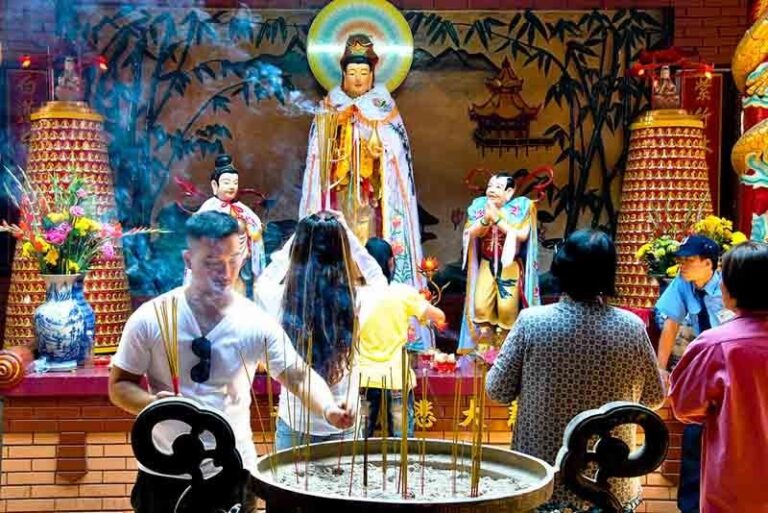 Fidèles faisant des offrandes devant une statue dans une pagode