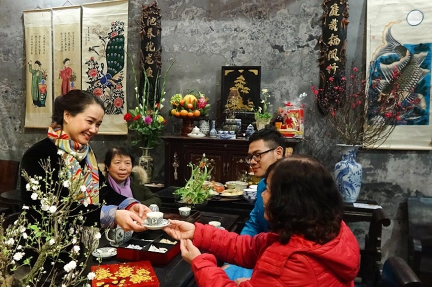 Une femme vietnamienne offrant le thé à ses aînés en signe de respect