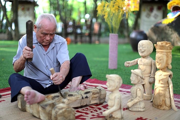 Artisan sculptant une figurine en bois de jacquier au Vietnam