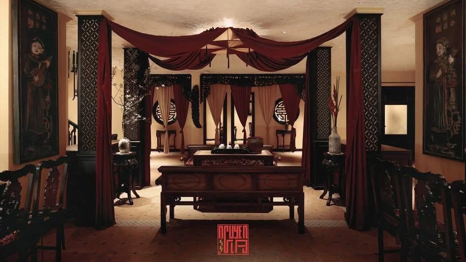 Salon interieur ancestral du restaurant Nguyen Gia avec boiseries et tentures rouges