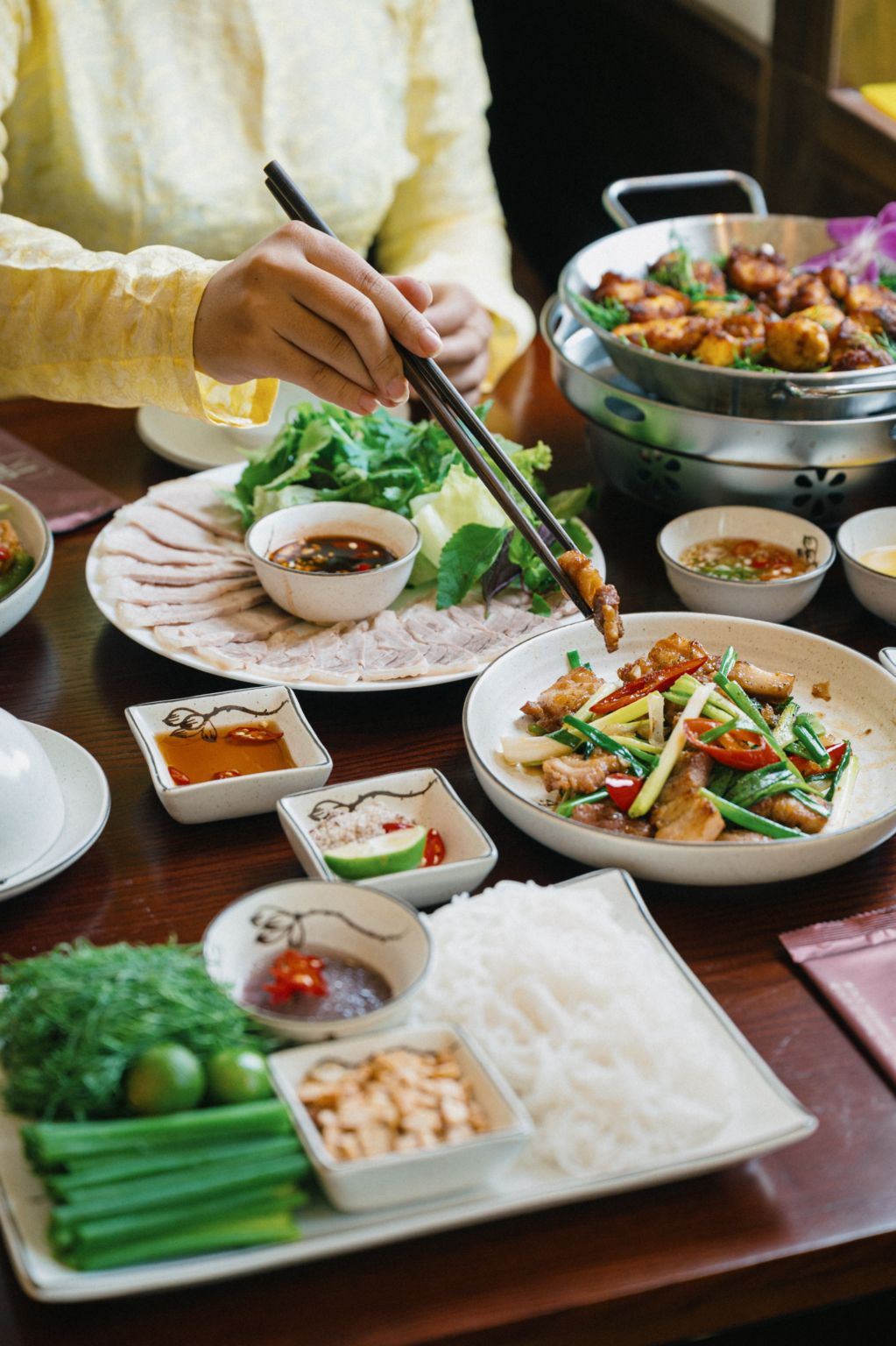Table dressee au restaurant Vi An a Hanoi avec cha ca et plats traditionnels