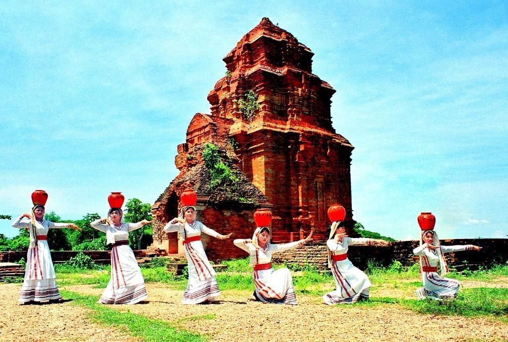 Danseuses cham portant des jarres rouges sur la tête devant les tours de Po Sah Inu
