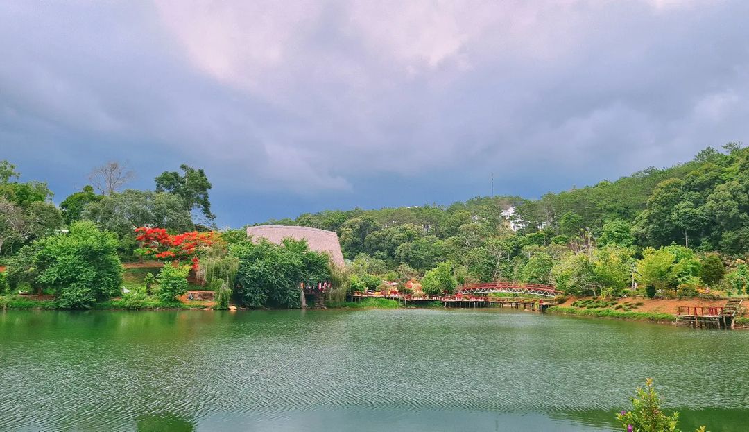 Lac Toong Đăm à Măng Đen avec nhà rông traditionnel et pont rouge