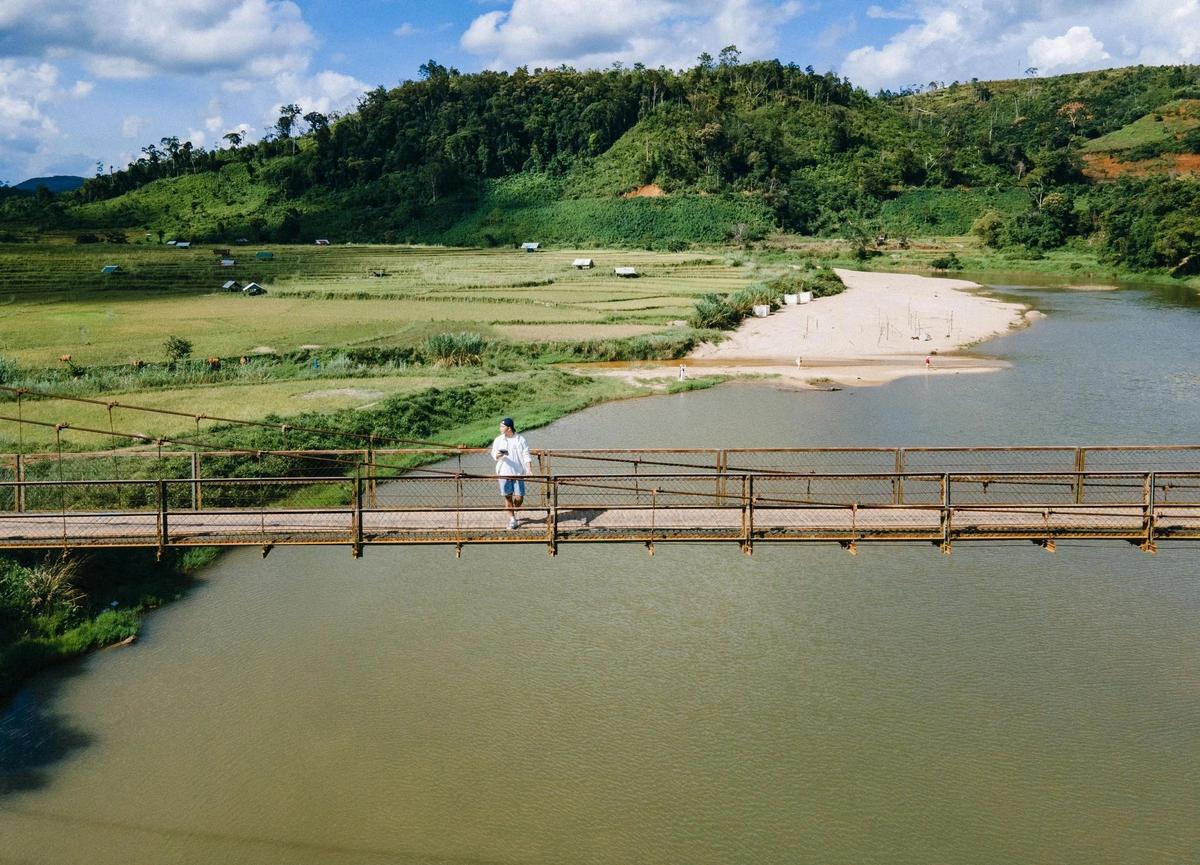 Promeneur traversant le pont suspendu de Kon Tu Rang au-dessus de la rivière