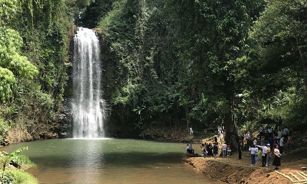 Visiteurs admirant la cascade de Pa Sy et son bassin naturel