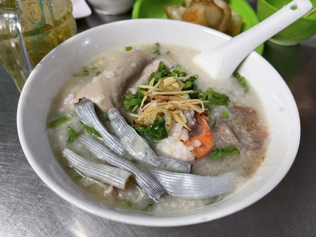 Cháo Tiều - Une bouillie de riz généreusement garnie d'abats de porc, de crevettes et d'herbes fraîches.