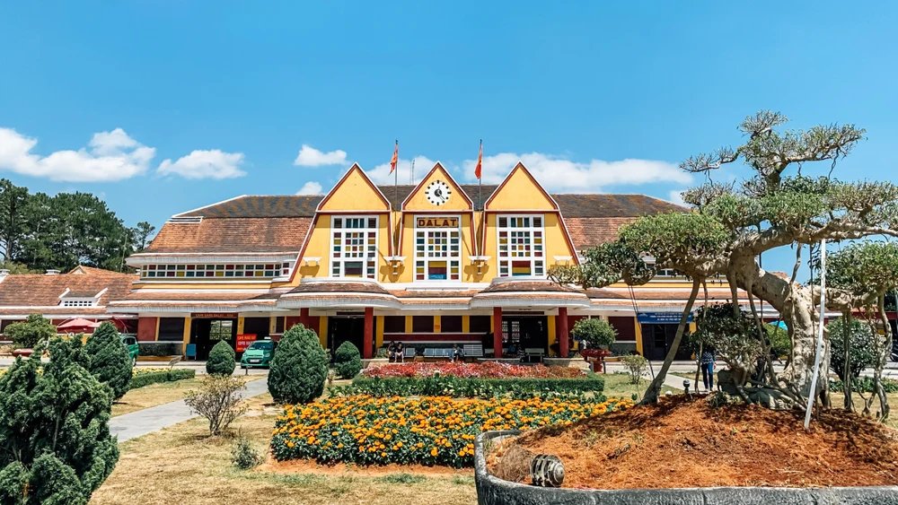 Façade de la gare ancienne de Dalat sous un ciel bleu.