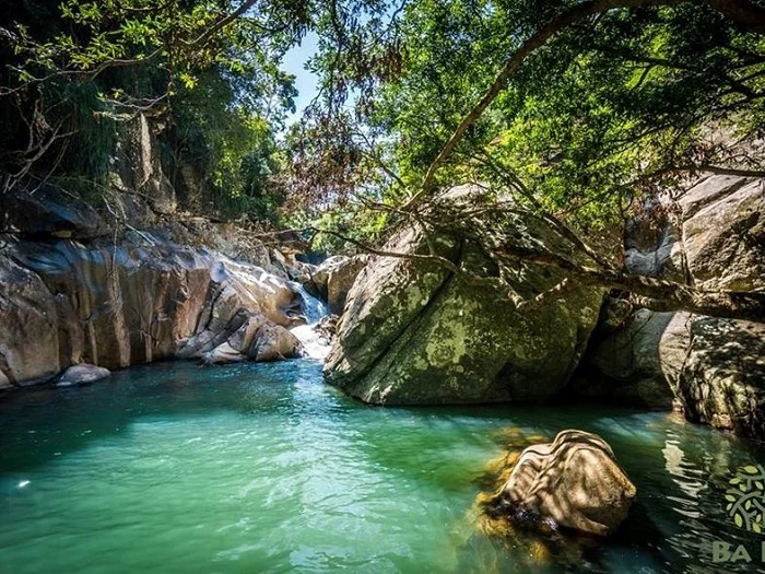 Bassin naturel turquoise entouré de rochers aux cascades de Ba Ho près de Nha Trang