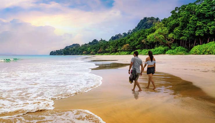 Voyageurs marchant sur une plage de la mer d’Andaman en Thaïlande