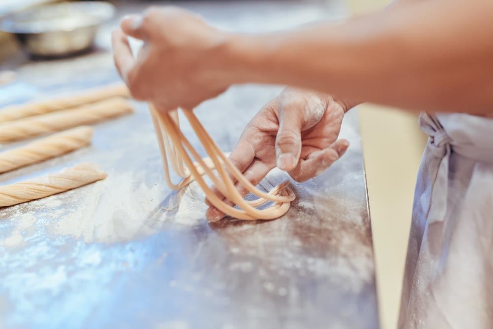 Fabrication artisanale des mì kéo : des nouilles chinoises étirées à la main selon une méthode traditionnelle.