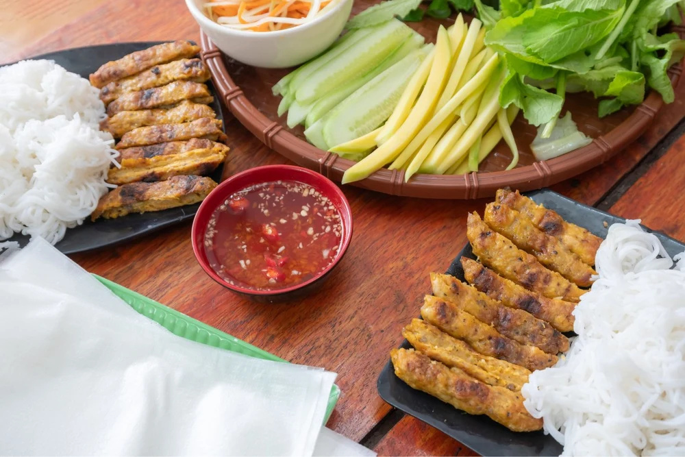 Nem nuong de Nha Trang servi avec herbes, mangue et galettes de riz
