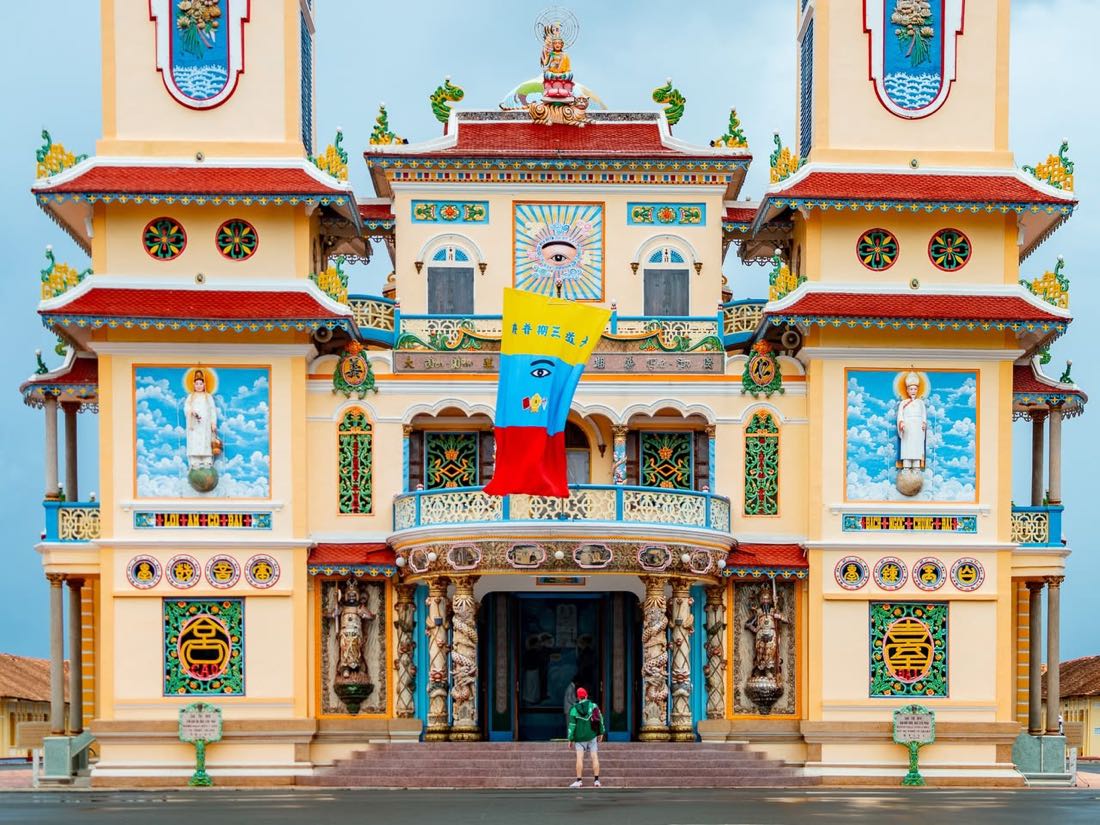 Œil divin et drapeau caodaïste sur la façade du Temple Cao Dai