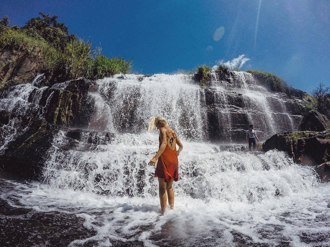 Voyageuse au pied de la cascade de Pongour pendant une période de fort débit.