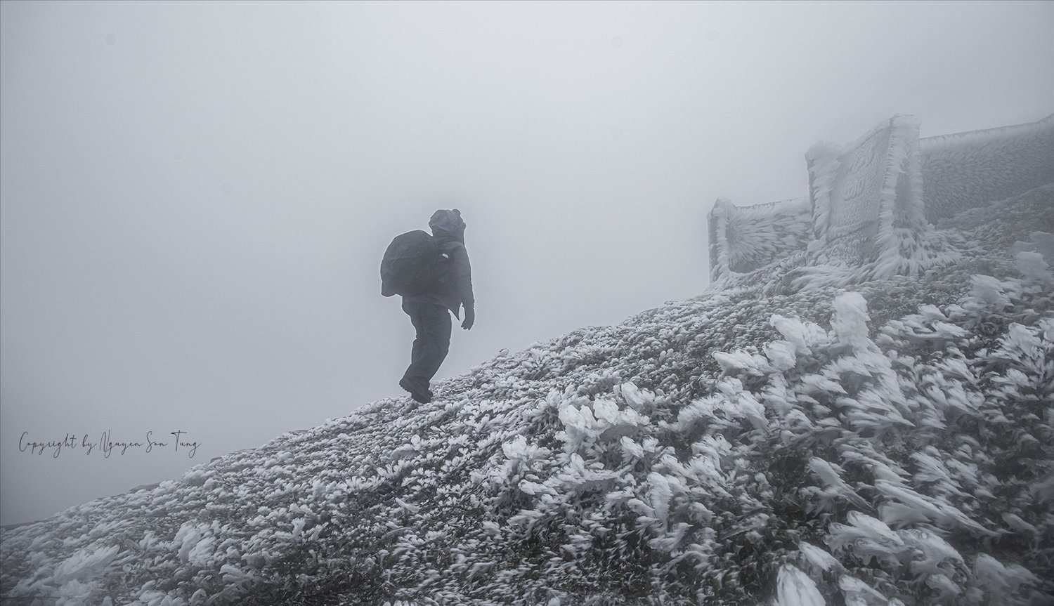 Randonneur avançant dans le brouillard et le givre à Mau Son.