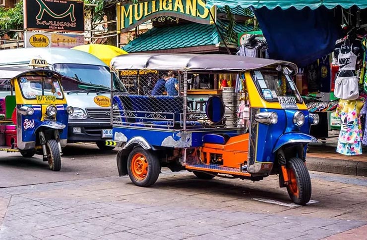 Tuk-tuk coloré circulant dans une rue de Bangkok